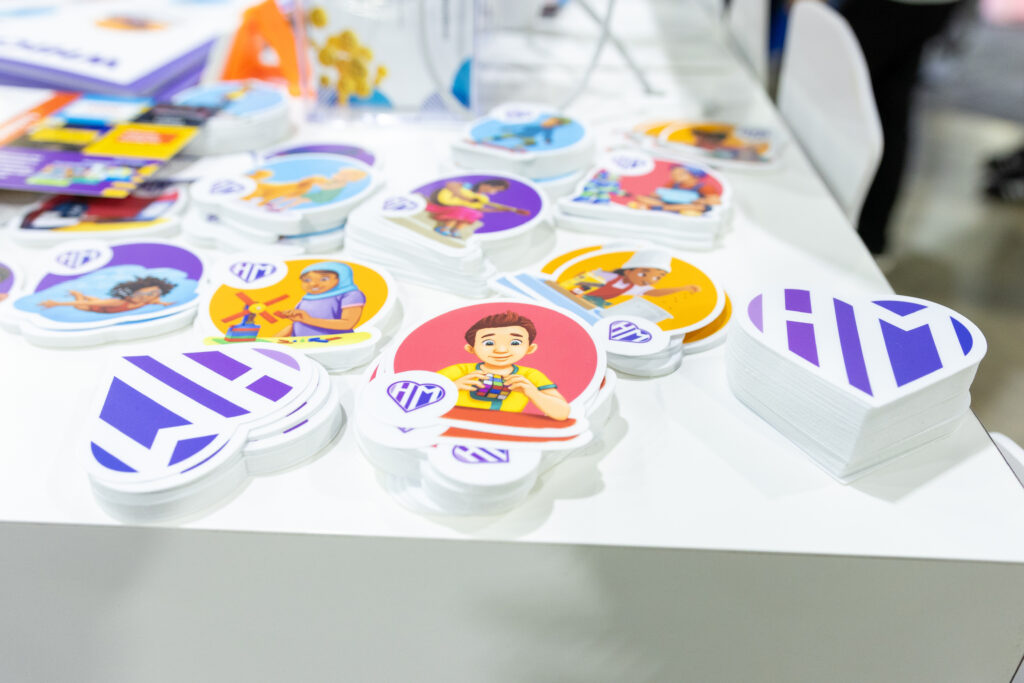 Humanizing Mathematics stickers sit on a table at NCTM 2025.
