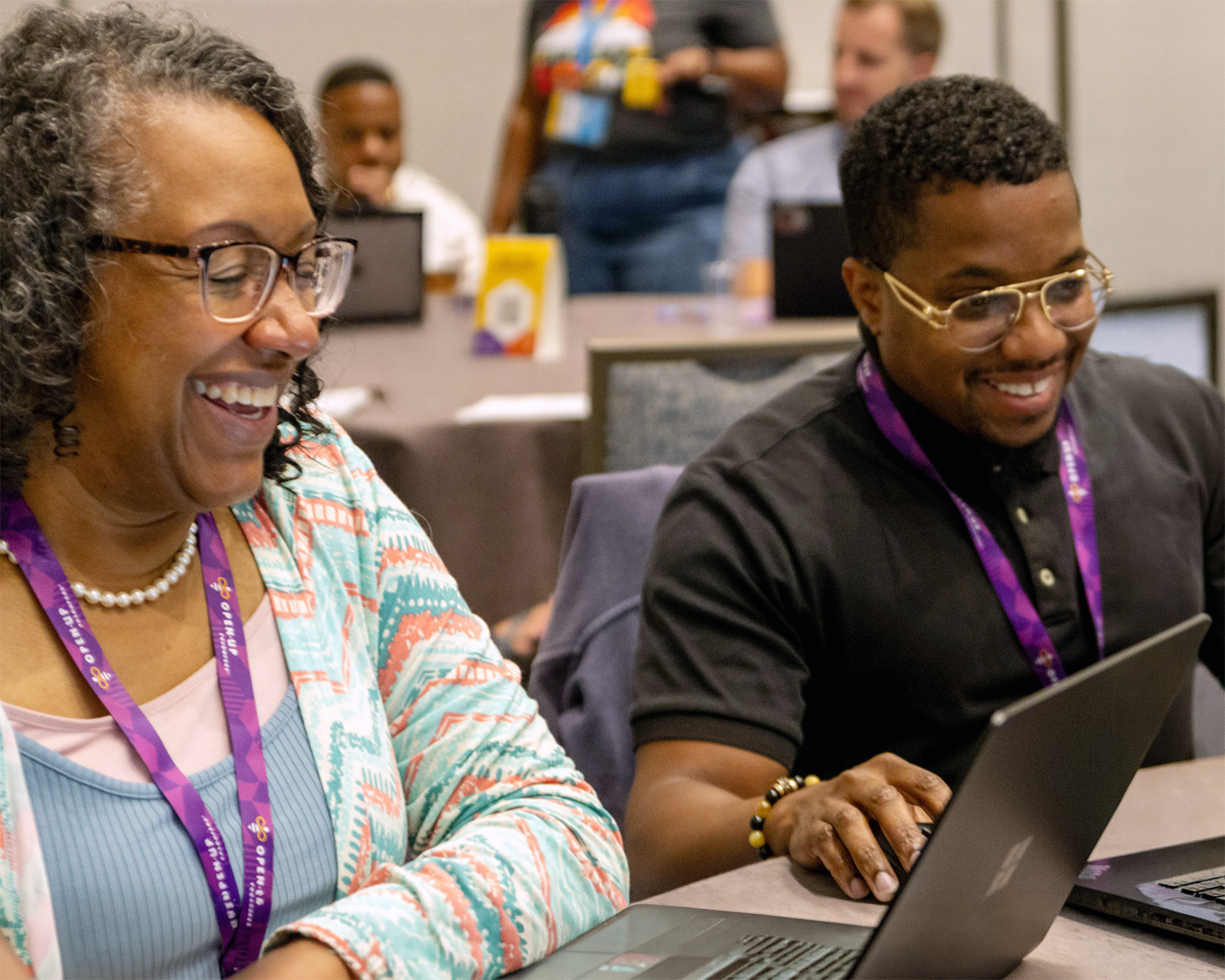 Two educators of dark skinned complexion work together at a table during a HIVE workshop.